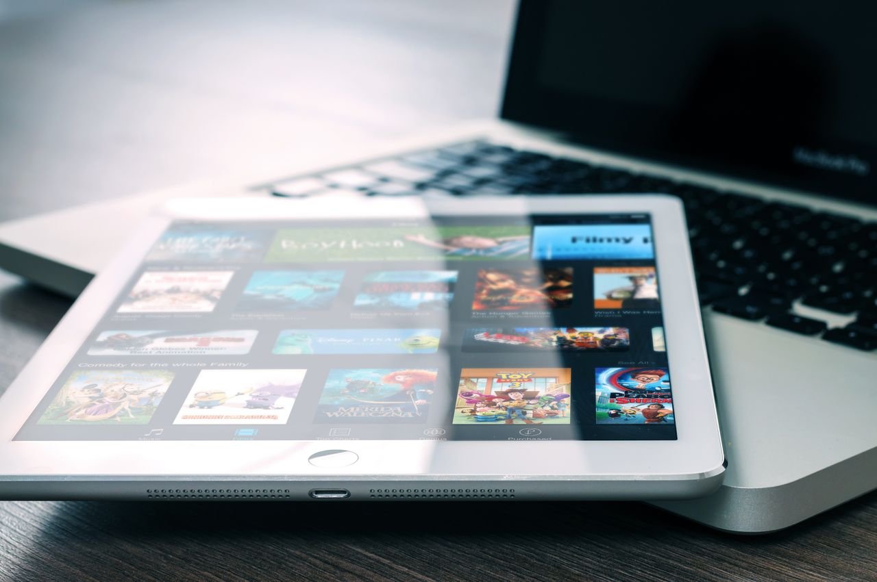 Tablet displaying streaming services on a laptop, illustrating digital entertainment setup.
